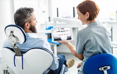 Emergency dentist in Jeffersonville, IN discussing dental X-rays with a patient during urgent care